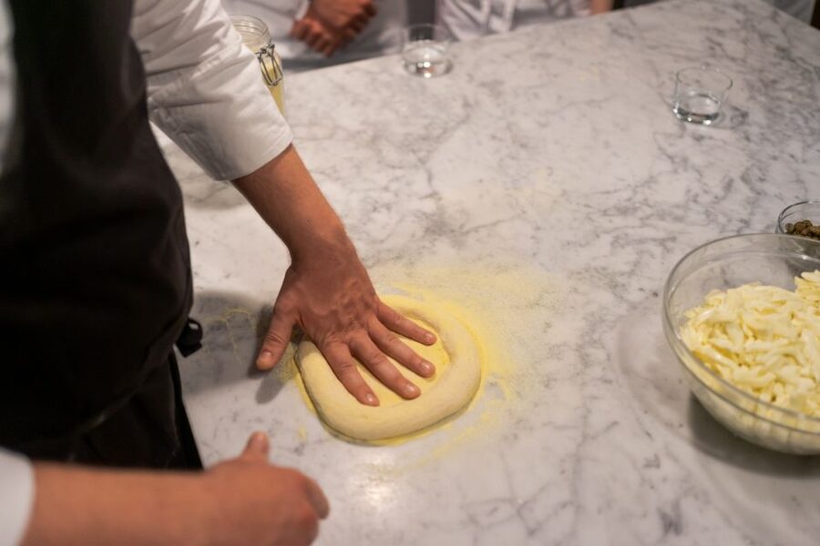Milan: Pizza or Pasta and Gelato-Making Class with Wine - Rolling pizza dough with a pizzaiolo